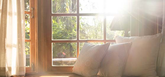 Living room with part of sofa in sunny day and white curtain