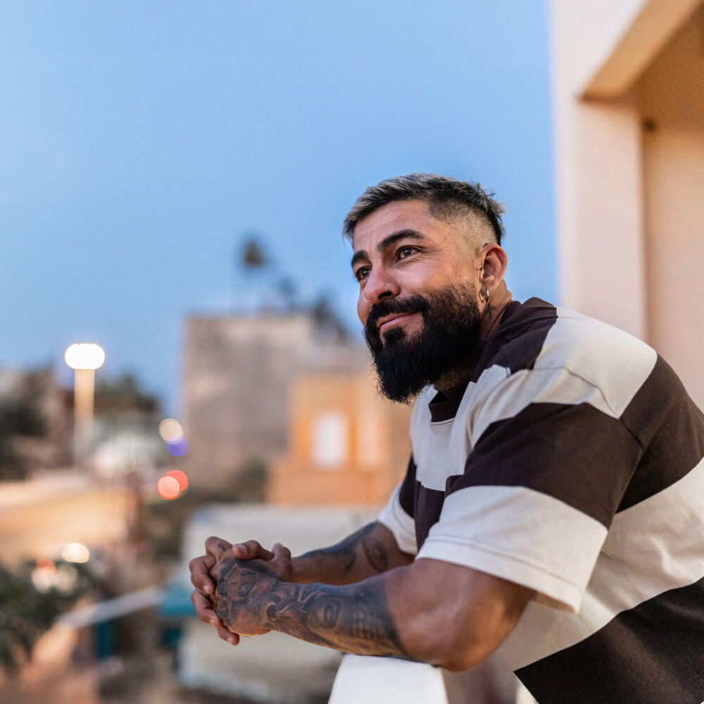 Mature man contemplating on balcony at home.